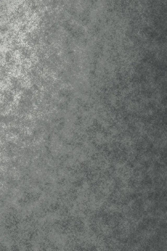 A rendered wall in raking light, its surface broken into fine grain and small hollows.