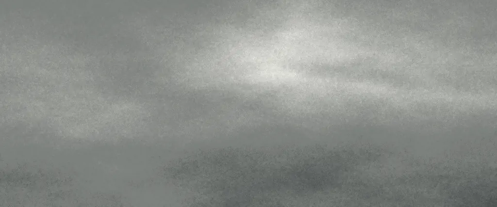 A heavy overcast sky, its cloud layers broken by a pale opening near the horizon.
